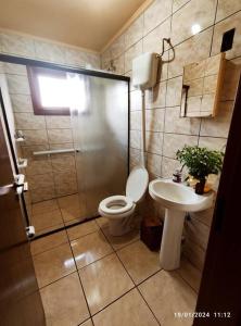 a bathroom with a shower and a toilet and a sink at Casa do pescador, na rota do Cristo Protetor in Estefânia