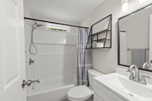 a white bathroom with a toilet and a sink at Downtown Dahlonega Destination in Dahlonega +36 photos