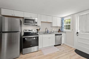 a kitchen with stainless steel appliances and white cabinets at Downtown Dahlonega Destination in Dahlonega