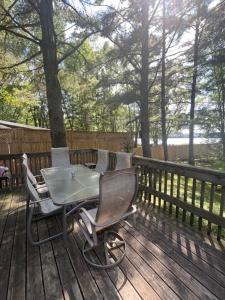 a table and chairs sitting on a wooden deck at The “Bear” waterfront cabin in Muskoka in Utterson