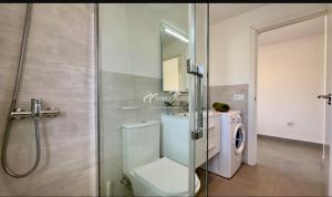a bathroom with a toilet and a washing machine at Penthouse Apartment Las Americas in Playa de las Americas +9 photos
