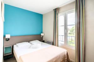 a bedroom with a white bed and a large window at Résidence Port Guillaume - maeva Home - Maison 3 pièces 6 personnes - Budget MAE-5714 in Dives-sur-Mer