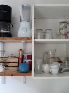 a kitchen cabinet filled with bowls and other kitchen utensils at Maison d'une chambre avec terrasse et wifi a Fort de France in Fort-de-France