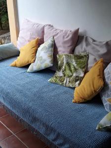 un montón de almohadas sentadas en una cama en Maison d'une chambre avec terrasse et wifi a Fort de France, en Fort-de-France