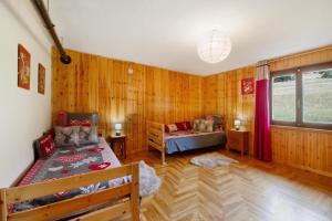 Cette chambre dispose de murs en bois, d'un lit et d'un canapé. dans l'établissement Alpine Majestic Escape - Balcone sulle Piste di Sci, à Champoluc