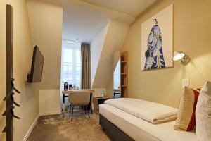 a hotel room with a bed and a desk at Zur Stadt Mainz - by homekeepers in Würzburg