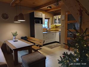 una cocina y una sala de estar con un árbol de Navidad. en Domki Na Źródlanej, en Międzybrodzie Bialskie