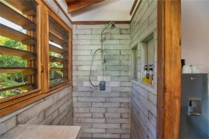 bagno con doccia in un muro di mattoni di Camp Bay Lodge a Roatán