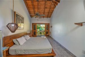 a bedroom with a bed and a ceiling fan at Camp Bay Lodge in Roatán