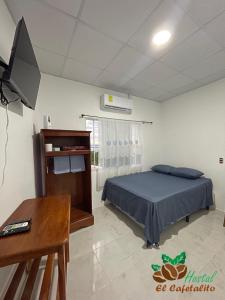 - une chambre avec un lit, une table et un bureau dans l'établissement Hotel y Restaurante El Cafetalito, à Conchagua