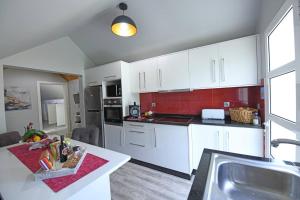 une cuisine avec des placards blancs et un comptoir dans l'établissement One bedroom house with wifi at Ponta do Sol, à Ponta do Sol