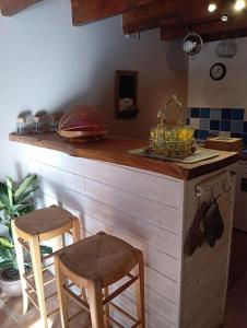 een keuken met een aanrecht met 2 krukken en een wastafel bij Maison avec piscine et patio in Cavaillon