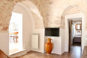 a living room with a tv and a vase in a room at Trullo a ll'éra in Ceglie Messapica