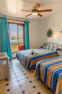 two beds in a room with a view of the ocean at Casa Juanita in Peniscola