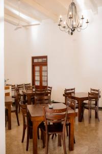 a dining room with wooden tables and chairs at Arches Fort in Galle