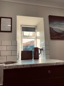 a kitchen counter with a coffee pot on a counter top at Ben Nevis Inn Rooms in Fort William