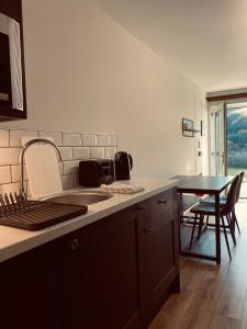 a kitchen with a sink and a table with chairs at Ben Nevis Inn Rooms in Fort William