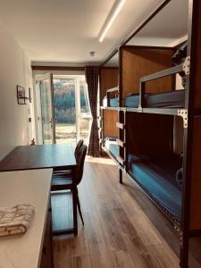 a room with bunk beds with a desk and a table at Ben Nevis Inn Rooms in Fort William