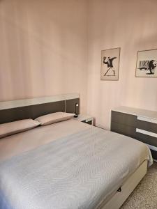 ein Schlafzimmer mit einem großen Bett und zwei Bildern an der Wand in der Unterkunft ANGOLO di MARE in Sanremo