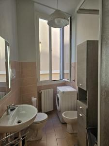 ein Badezimmer mit einem Waschbecken, einem WC und einem Spiegel in der Unterkunft ANGOLO di MARE in Sanremo
