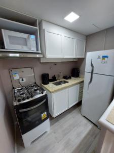a small kitchen with a stove and a refrigerator at Flat Champ's Elysées in Sao Paulo
