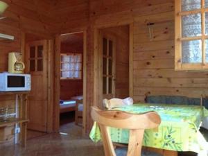 ein Schlafzimmer einer Blockhütte mit einem Bett darin in der Unterkunft Chalet - Piscine - ef0aac in Porto-Vecchio