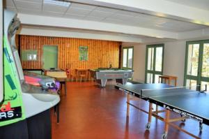 una sala de ping pong con mesas de ping pong y una mesa de ping pong en Maison 3 étoiles - Piscine - eeeggg, en Meyrueis