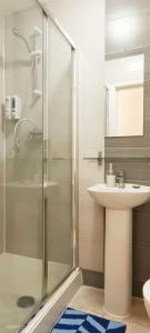 a bathroom with a glass shower and a sink at Iris Apartment in Wembley in London