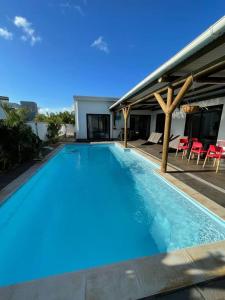uma piscina com água azul numa casa em 4 bedrooms house at Pointe aux Sables 800 m away from the beach with private pool terrace and wifi em Petite Rivière