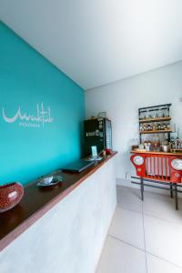 un restaurant avec un mur bleu et un comptoir dans l'établissement Pousada Maktub, à Carolina