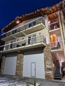 a house with two garage doors and two balconies at Pensiunea CUZA in Borşa