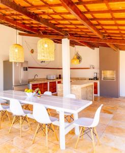 une cuisine avec une grande table blanche et des chaises dans l'établissement Refugios Parajuru - Villa Palmeira, à Beberibe