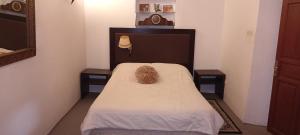 Ce lit se trouve dans un dortoir doté de 2 tables de chevet. dans l'établissement Riad Le Lieu, à Tiznit