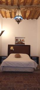 Un dormitorio con una cama grande y una lámpara de araña. en Riad Le Lieu, en Tiznit