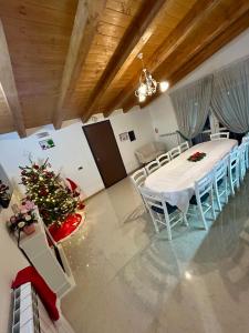 a dining room with a table and chairs and a christmas tree at Pensiunea CUZA in Borşa +30 photos