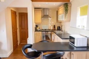 a kitchen with a black counter top and a microwave at Grange Farm Cottages, Wressle in Selby