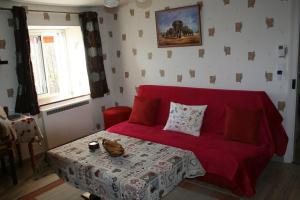 - un salon avec un canapé rouge et une table dans l'établissement Propriete d'une chambre avec wifi a Fraize, à Fraize