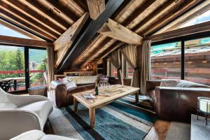 a living room with leather furniture and a table at Résidence Oursnoir - Chalets pour 10 Personnes 224 in Val-d'Isère