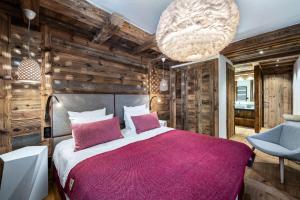 a bedroom with a large bed and a large chandelier at Résidence Oursnoir - Chalets pour 10 Personnes 224 in Val-d'Isère