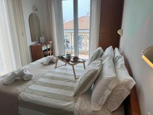 a bedroom with a bed with pillows and a balcony at Hotel Villa Caterina in Rimini