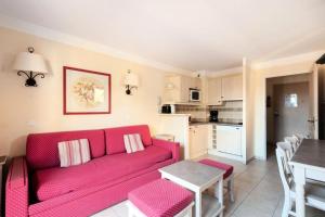 - un salon avec un canapé rouge et une table dans l'établissement Les Coteaux de Pont Royal en Provence - maeva Home - Appartement 3 pièces 6 214, à Mallemort