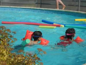 two children playing in a swimming pool with toys at Chalet - Piscine - eecfce in Salles-Curan