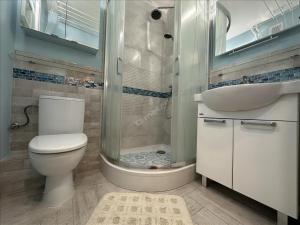 a bathroom with a toilet and a sink and a shower at First Green Żoliborz Apartment 9 in Warsaw