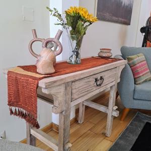 a table with a vase of flowers on top of it at Balconcito Peruano& Ciudad real 302 & 2 bedroom in Lima