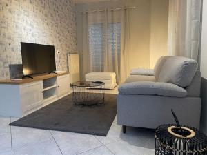a living room with a couch and a flat screen tv at Letty's cozy flat apartment in Perea
