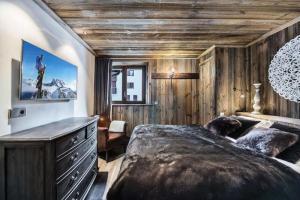 - une chambre avec un grand lit et une commode dans l'établissement Residence La Canadienne - Pièces 524, à Val dʼIsère