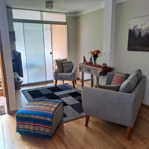 Balconcito Peruano& Ciudad real 302 & 2 bedroom في ليما: غرفة معيشة مع أريكة وكراسي وطاولة