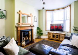 - un salon avec un canapé et une télévision dans l'établissement Spacious Victorian House By AV Hughes Properties Short Lets & Serviced Accommodation Northampton with Fast Wi-Fi and Free Parking, à Northampton