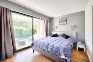 une chambre avec un lit et une grande fenêtre dans l'établissement Résidence Le Saint Denac - maeva Home - Appartement 2 pièces 4 personnes - Prestige MAE-4234, à Saint-André-des-Eaux