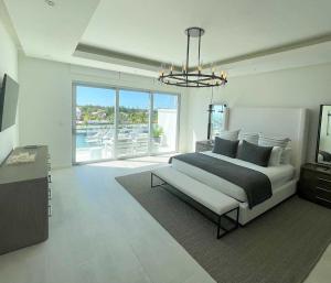 a white bedroom with a bed and a large window at Palm Cay Marina and Resort in Nassau